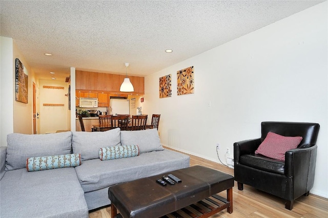 living room featuring a textured ceiling and light wood-type flooring