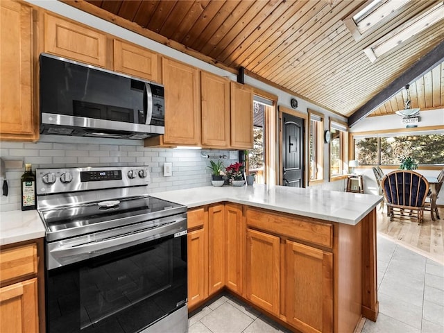 kitchen featuring backsplash, light tile patterned floors, kitchen peninsula, stainless steel appliances, and wooden ceiling