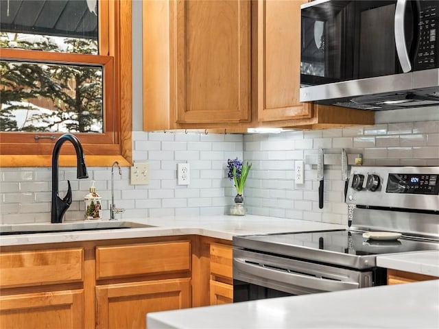 kitchen with stainless steel appliances, sink, and backsplash