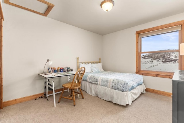 bedroom with light carpet, attic access, and baseboards