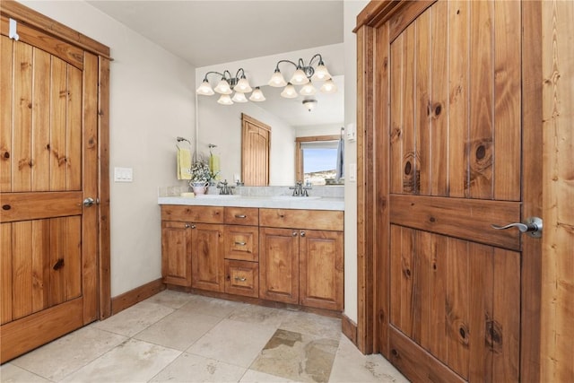 full bath featuring a sink, baseboards, and double vanity