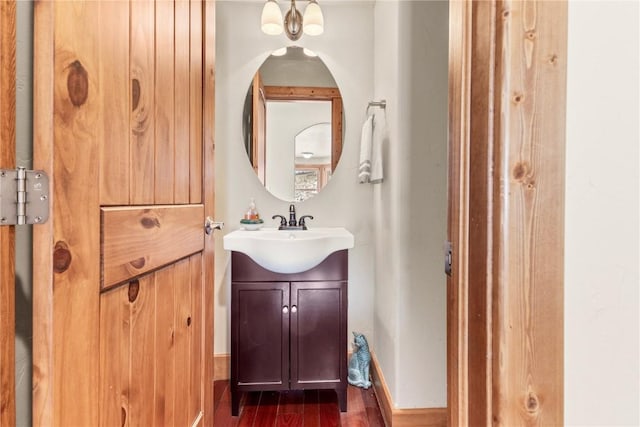 bathroom with baseboards, wood finished floors, and vanity