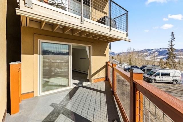 balcony featuring a mountain view and a baseboard heating unit