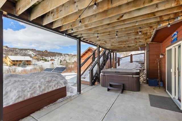 snow covered patio featuring a hot tub