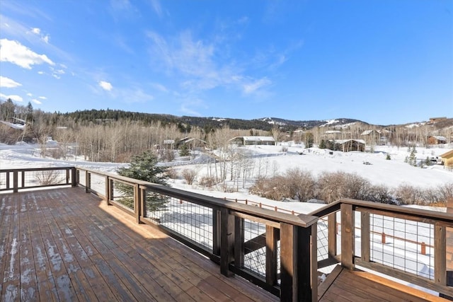 snow covered deck with a mountain view