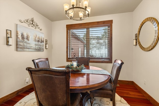 dining area featuring a chandelier, wood finished floors, and baseboards