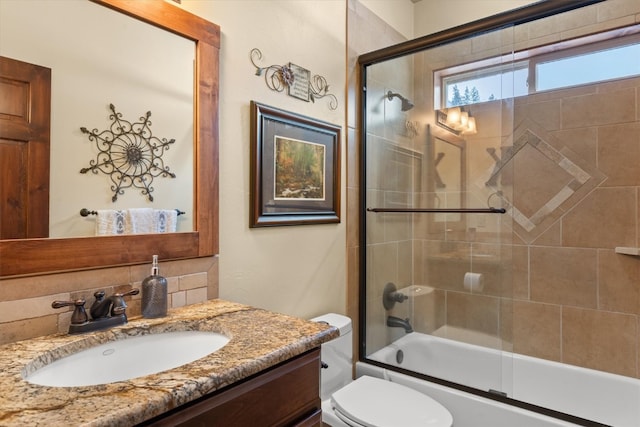 full bath with combined bath / shower with glass door, vanity, and toilet