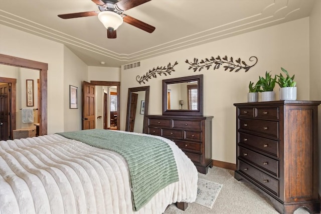 bedroom with baseboards, visible vents, connected bathroom, light colored carpet, and ceiling fan