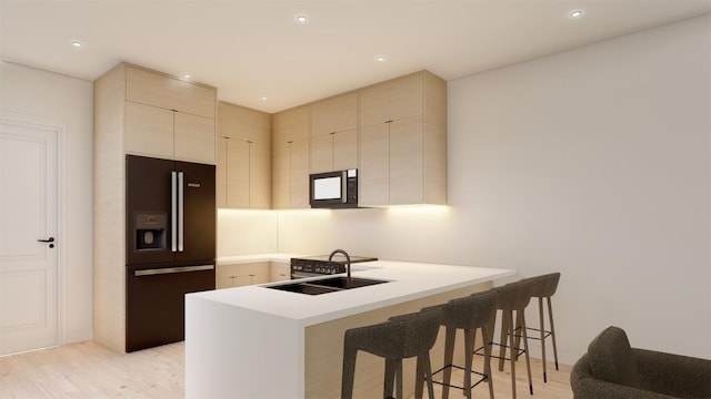 kitchen with sink, black refrigerator with ice dispenser, kitchen peninsula, light hardwood / wood-style floors, and a breakfast bar area