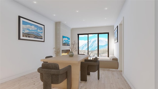 dining area featuring a high end fireplace and light hardwood / wood-style floors