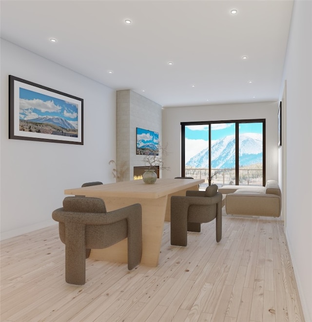 dining area with a fireplace and light hardwood / wood-style flooring