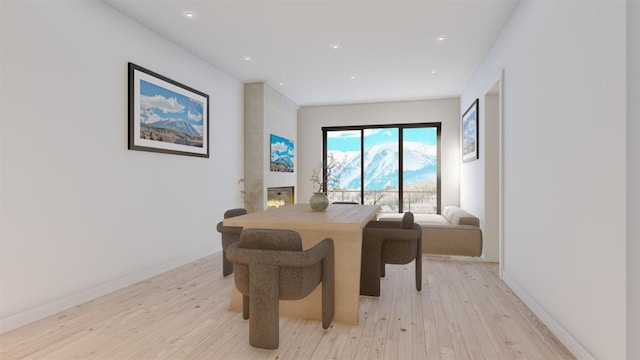 dining space with a fireplace and light hardwood / wood-style floors