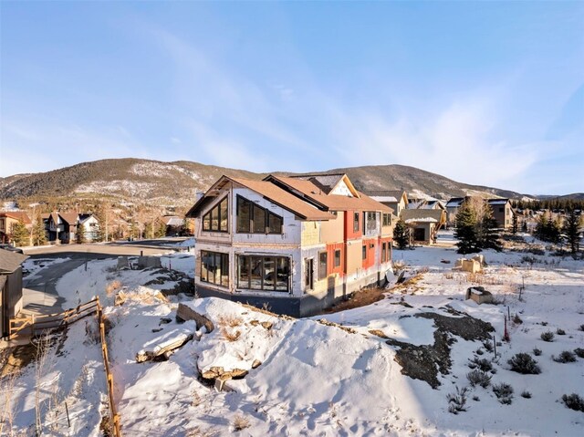 snow covered back of property with a mountain view