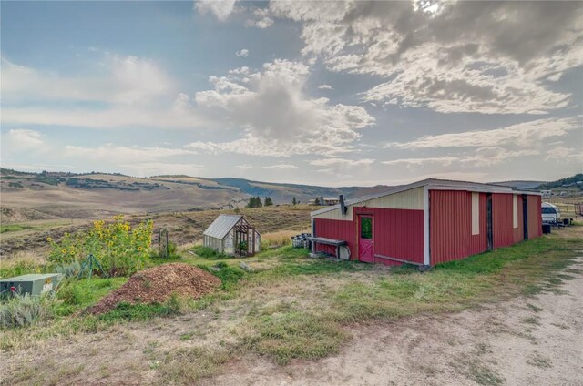 view of yard with a mountain view, an outbuilding, and a pole building