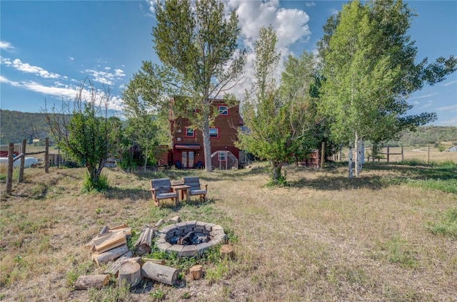 view of yard with a fire pit and fence