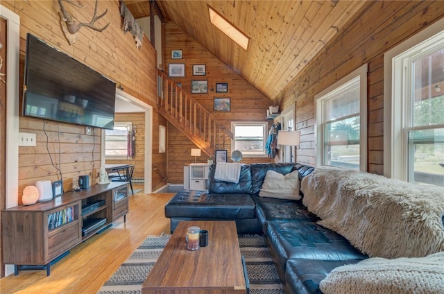 living room featuring a wealth of natural light, wood ceiling, and wood walls