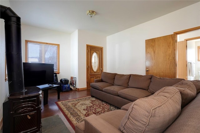 living room with dark hardwood / wood-style floors and a wood stove