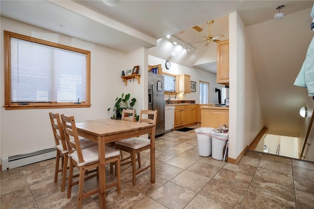 dining area with sink, vaulted ceiling, a baseboard radiator, track lighting, and ceiling fan