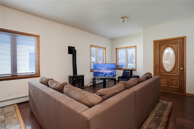 living room with a baseboard radiator, a wood stove, and dark wood-type flooring