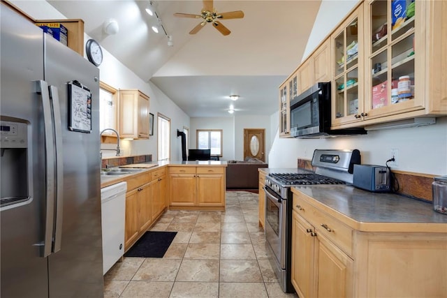 kitchen with vaulted ceiling, light brown cabinetry, sink, kitchen peninsula, and stainless steel appliances