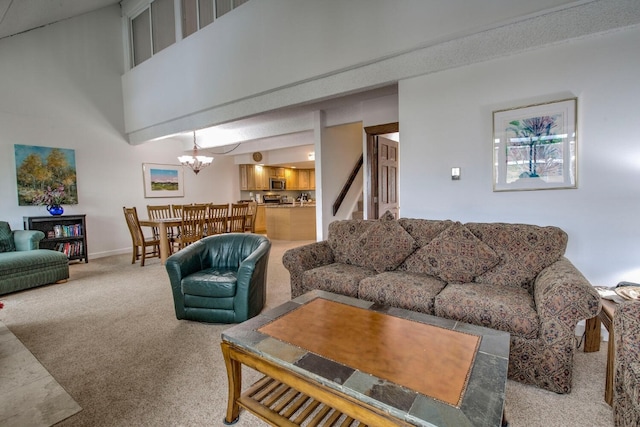 living room featuring carpet, a towering ceiling, and an inviting chandelier