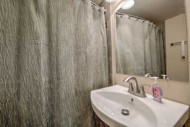 bathroom with sink and a shower with shower curtain