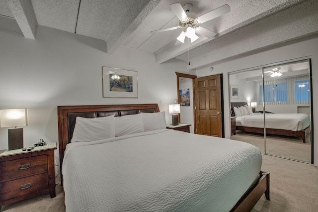 bedroom with beamed ceiling, light colored carpet, a textured ceiling, and a closet