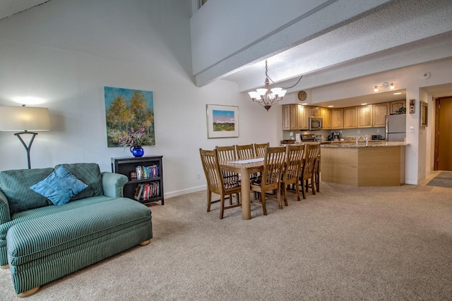 carpeted dining area featuring sink, a high ceiling, beam ceiling, and a notable chandelier