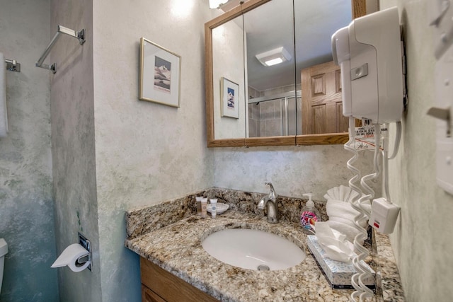 bathroom featuring walk in shower and vanity