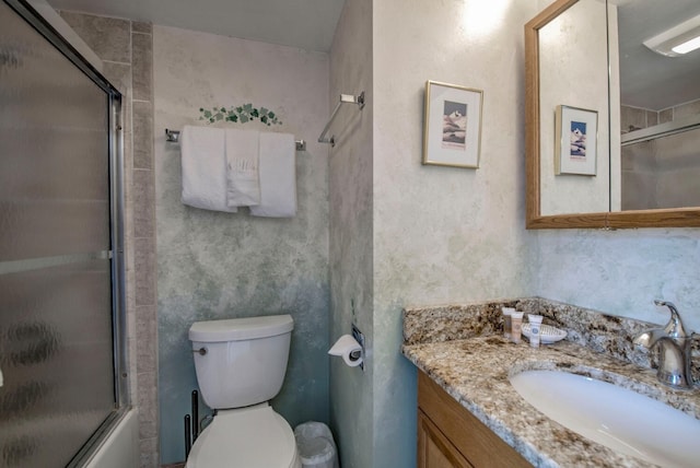 full bathroom featuring vanity, enclosed tub / shower combo, and toilet