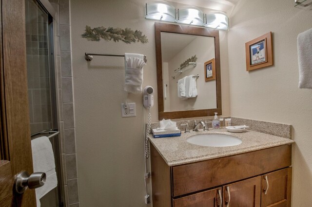 bathroom featuring vanity and a shower with door