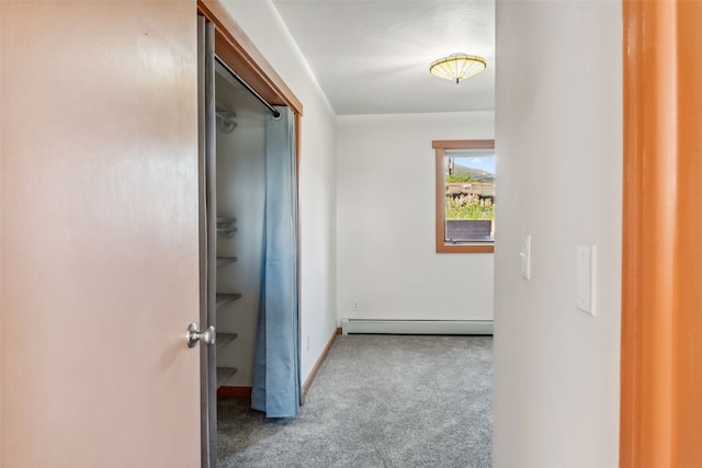 hall with light colored carpet and a baseboard heating unit