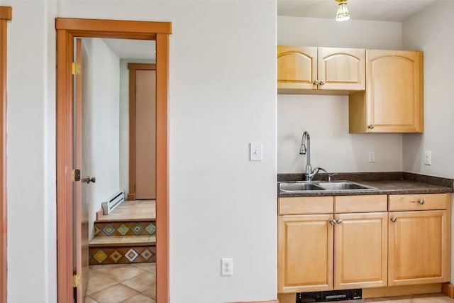 kitchen with light tile patterned floors, light brown cabinets, baseboard heating, and sink