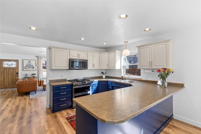 kitchen with white cabinetry, hanging light fixtures, stainless steel appliances, blue cabinets, and kitchen peninsula