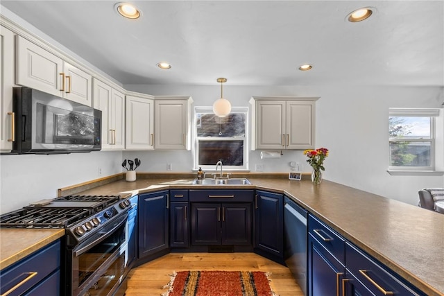 kitchen with white cabinetry, appliances with stainless steel finishes, sink, and blue cabinetry