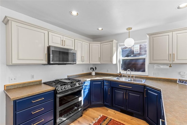 kitchen with white cabinetry, appliances with stainless steel finishes, blue cabinets, and sink