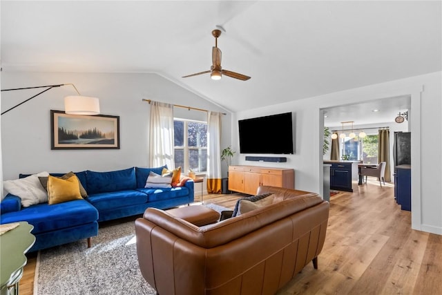 living room with ceiling fan, lofted ceiling, and light wood-type flooring