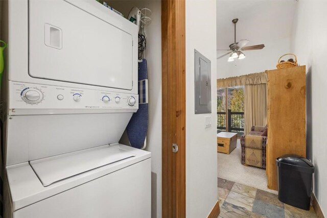 laundry area featuring stacked washer / drying machine, ceiling fan, and electric panel