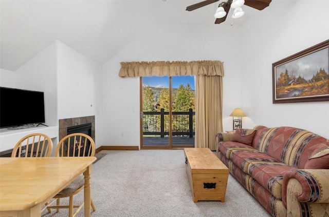 living room with light carpet, ceiling fan, lofted ceiling, and a tiled fireplace