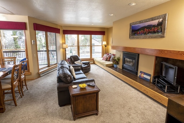 carpeted living room featuring a tiled fireplace and a textured ceiling