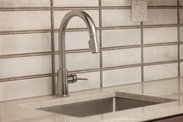 room details featuring a sink and light stone counters