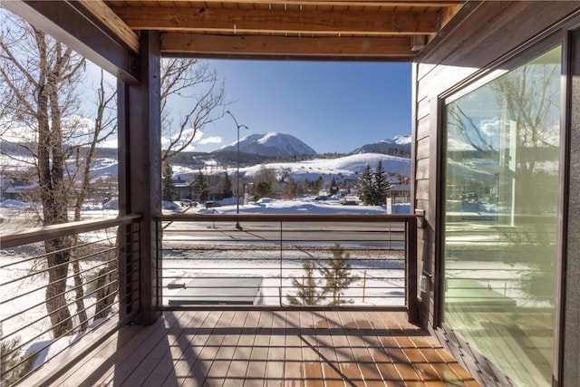 snow covered deck with a mountain view