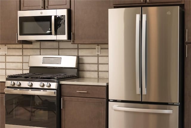 kitchen featuring dark brown cabinets, backsplash, stainless steel appliances, and light countertops