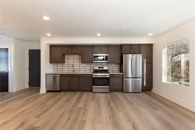 kitchen featuring dark brown cabinetry, appliances with stainless steel finishes, tasteful backsplash, and light countertops