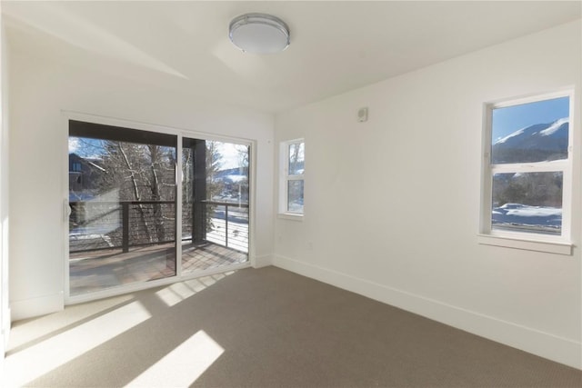 carpeted spare room featuring baseboards