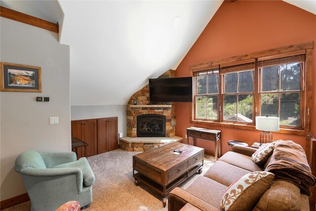 living room with lofted ceiling, a stone fireplace, and carpet floors