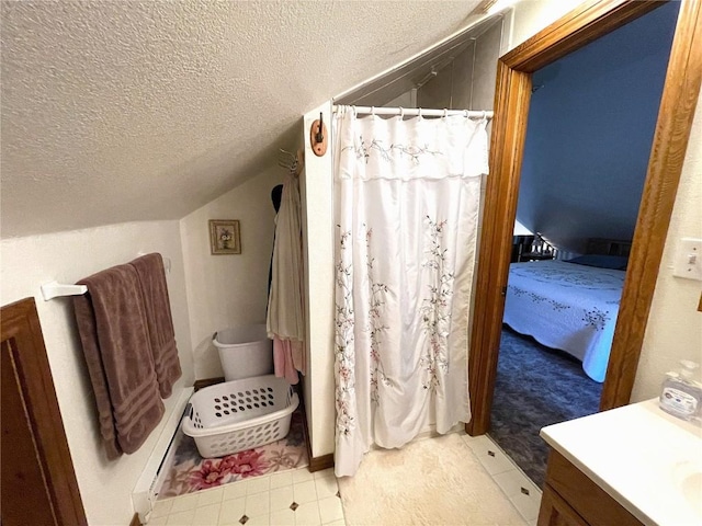 bathroom with a shower with shower curtain, a textured ceiling, vanity, and lofted ceiling