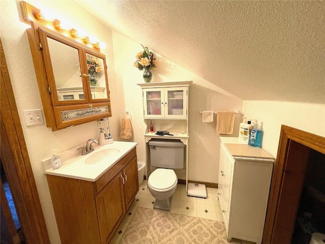 bathroom featuring vanity, lofted ceiling, tile patterned floors, toilet, and a textured ceiling