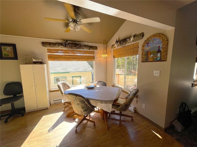 dining area featuring a baseboard heating unit, hardwood / wood-style flooring, ceiling fan, and lofted ceiling