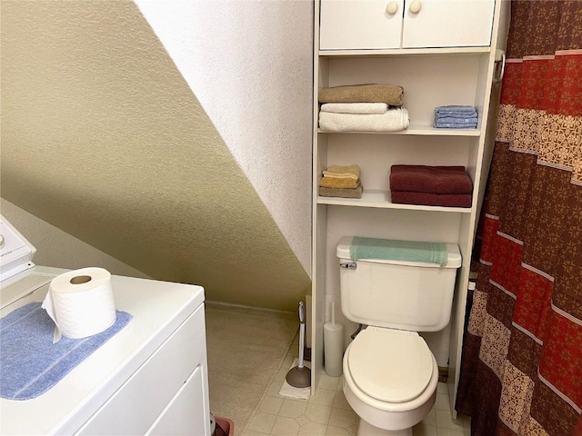 bathroom with toilet and washer / clothes dryer